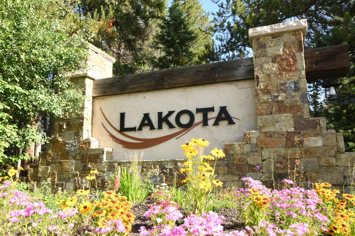 This exterior image captures the inviting entrance to the property, with welcoming signage, flower beds, and lush natural surroundings. The scene hints at privacy and an exclusive environment, setting the stage for a secluded romantic escape.