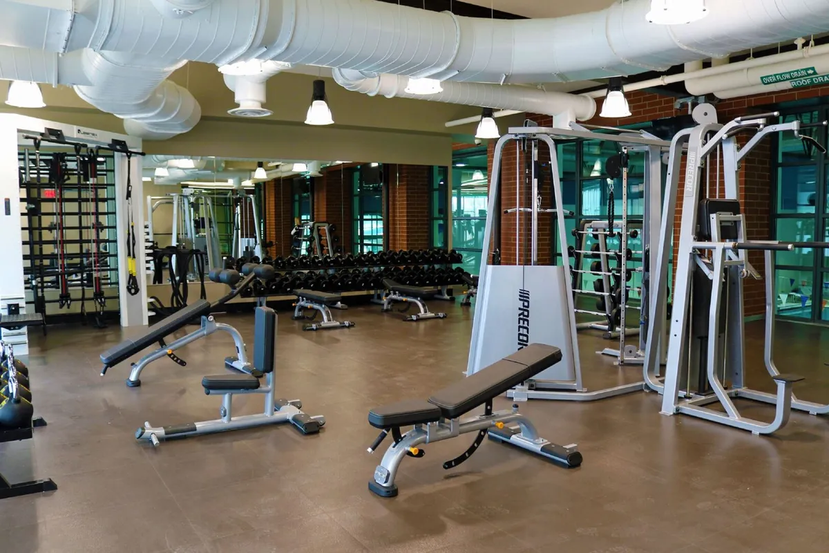 A well-equipped fitness area with weightlifting equipment, exercise benches, and mirrored walls. The space exudes energy and motivation, inviting guests to stay active and pursue their fitness goals.